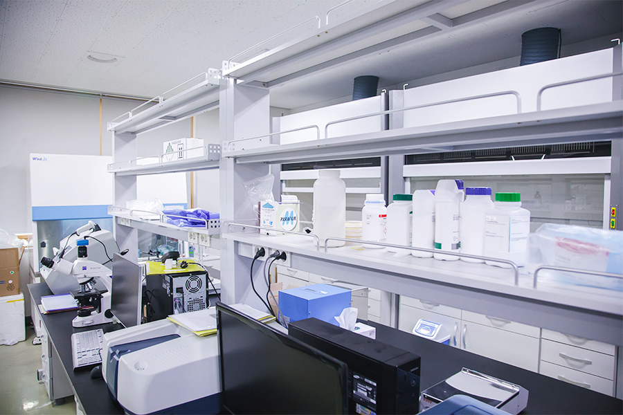 미생물실험실의 오른쪽 측면모습으로 테이블에 각종 기구들이 정돈되어 있으며 상단 선반에는 약품들이 줄지어 있다. 